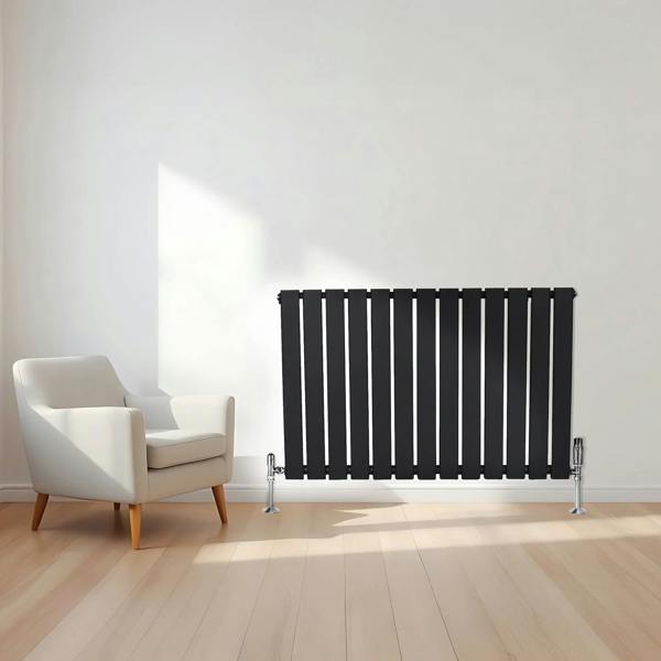 Flat black single column radiator, 600 x 910mm, featuring vertical slats, sleek design, and modern chrome feet, positioned near a stylish armchair
