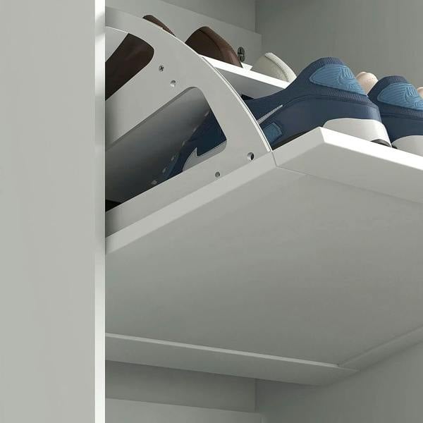 Close-up of open white shoe cabinet compartment holding shoes