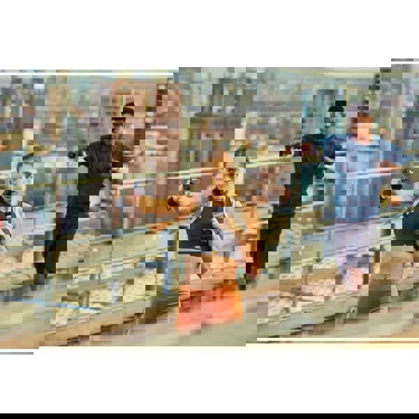 Two people exercising on a rooftop with cityscape in the background