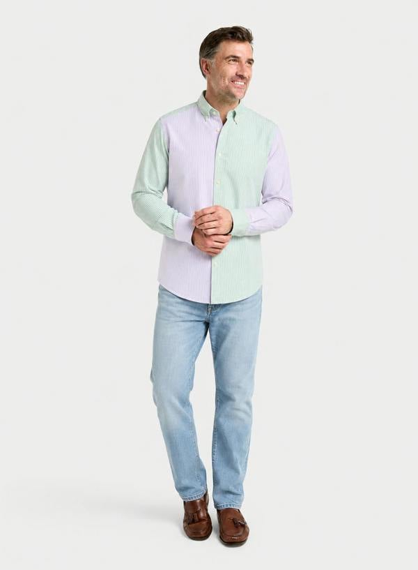 Man wearing a lilac and green patch stripe Oxford button-down shirt with blue jeans, full-length front view