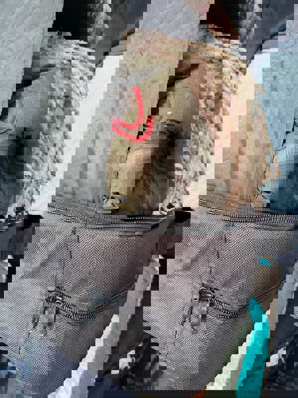 A closeup of the storage bag in the Camping Organiser with Shelves and Storage bag which contains clothing and blankets.