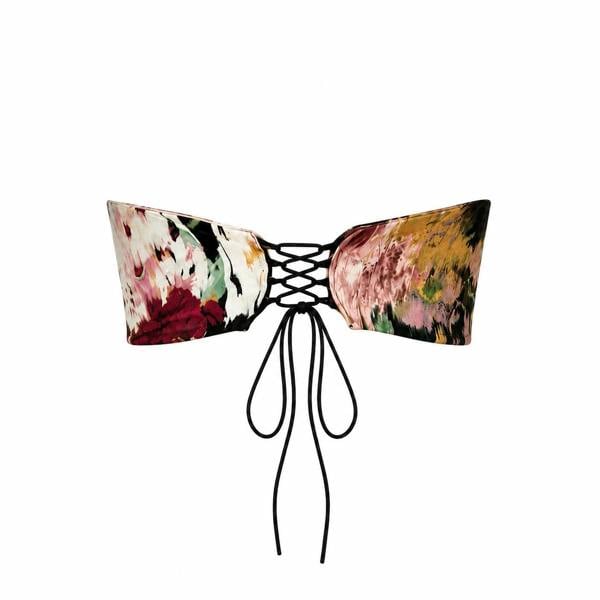 The Sarvin Ivy Corset Top is a strapless piece with a vibrant floral print on a plain white background, featuring black lace-up ties at the front.
