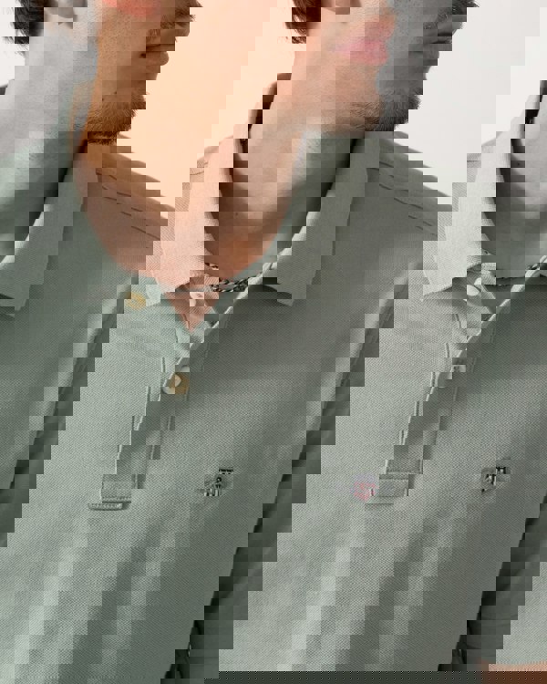 Close up of a Model wearing a GANT Mens Regular Fit Short Sleeve Shield Logo Pique Polo in Ceramic Grey