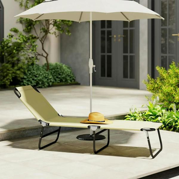 Beige foldable sun lounger with attached umbrella and black steel frame on patio