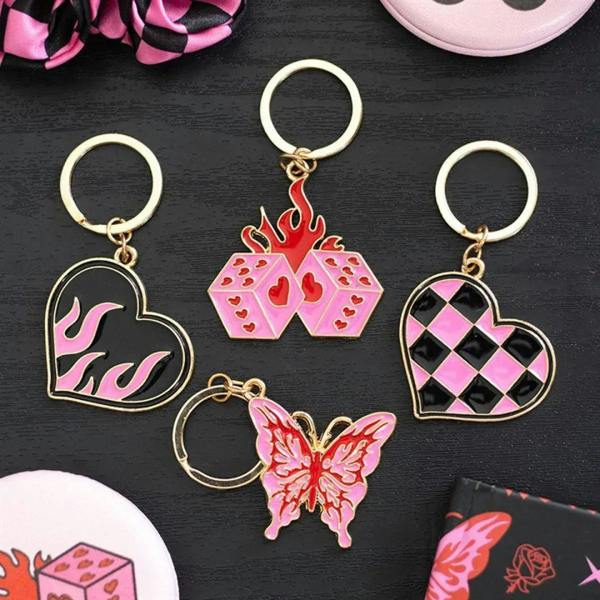 Assorted enamel keychains with heart charms, including pink-and-black checkerboard heart