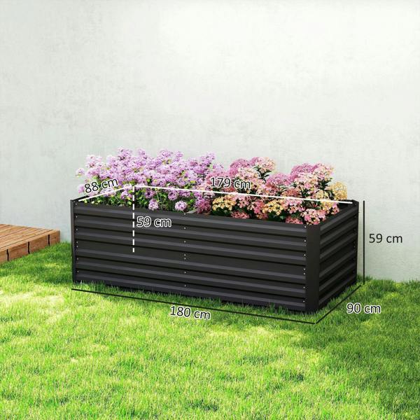 Black raised garden bed planter on grass, filled with flowering plants