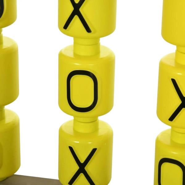 Close-up of yellow board game pieces with X and O symbols on the sandpit
