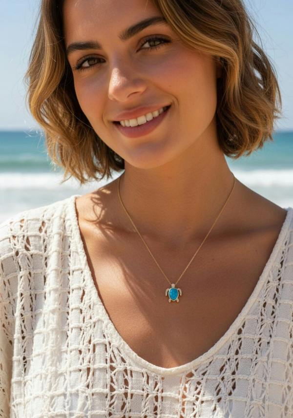 Woman wearing a turquoise turtle necklace with a blue pendant on a beach