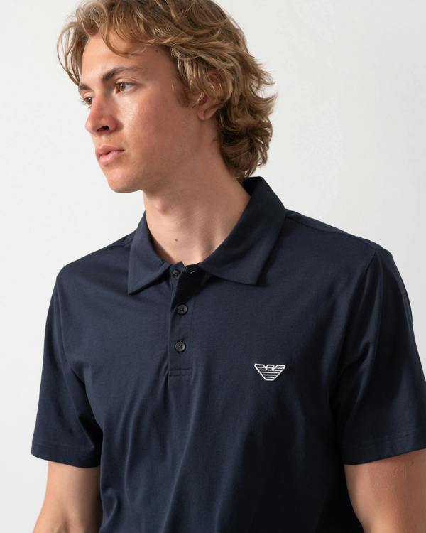 close up of model wearing an Emporio Armani Mens Beach Polo with Eagle Logo in Armani Blue