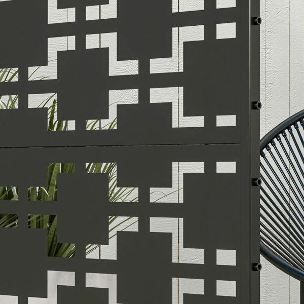 Close-up of black metal privacy screen divider showing geometric cutout pattern