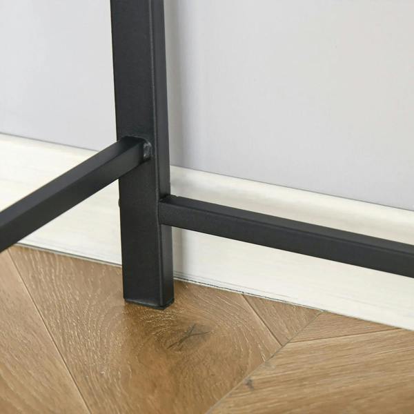 Black desk leg and crossbar with protective base on light wood floor.