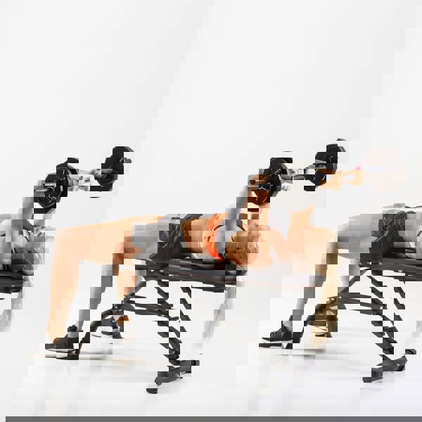 Woman performing Skullcrushers on a HXGN Ultimate Dumbbell Weight Bench 