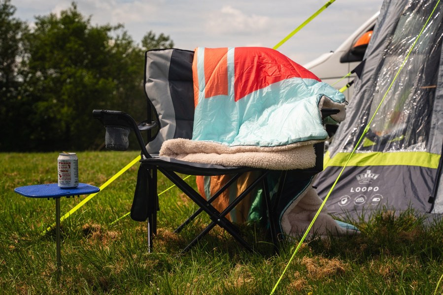 Tonal tree tops, Insulated Outdoor Blanko by OLPRO, hung over a camping chair showing is vibrant design and plush sherpa fleece lining. imageset:Tonal Tree Tops