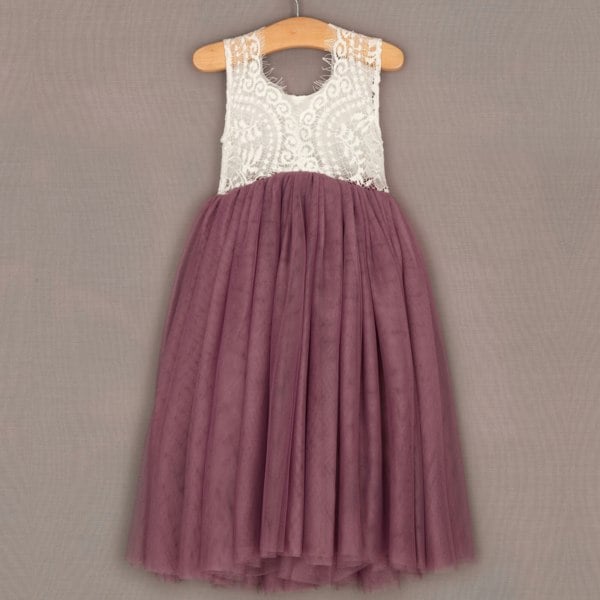Dress with white lace top and purple skirt on a hanger against a gray background