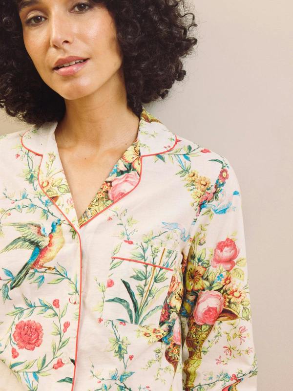 Woman wearing a floral pyjama top with a neutral background