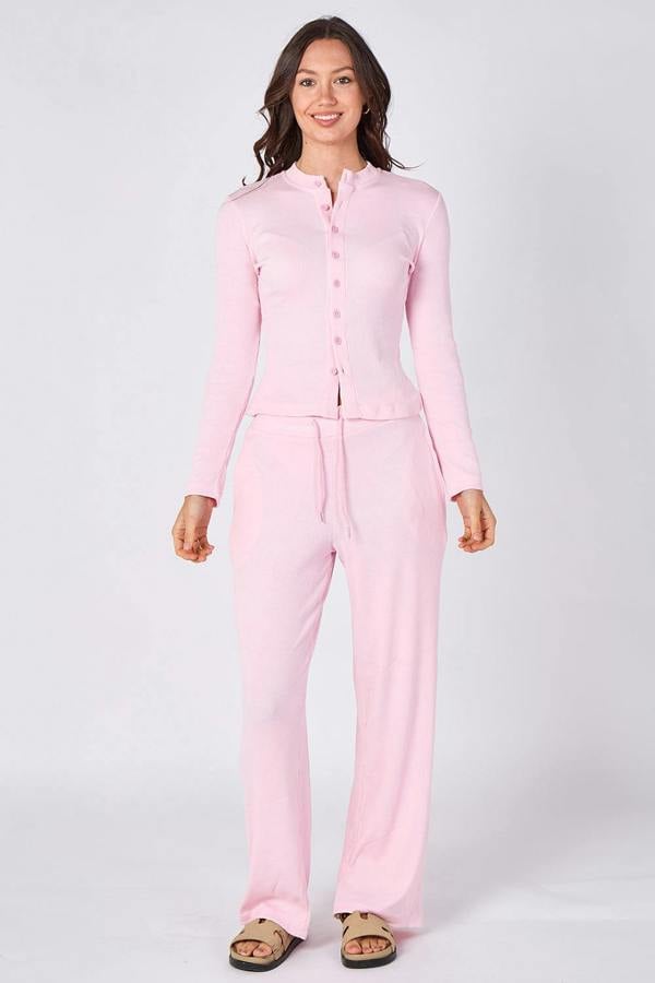 Woman wearing a pink pajama set on a white background