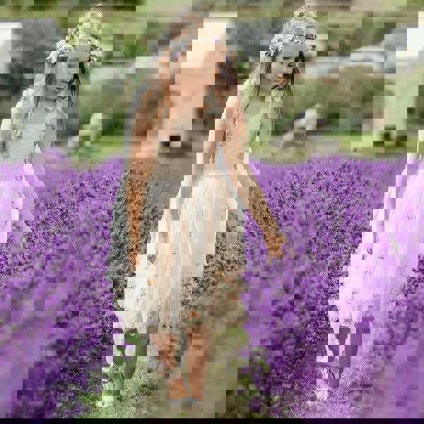 Young girl in a floral dress standing in a lavender field