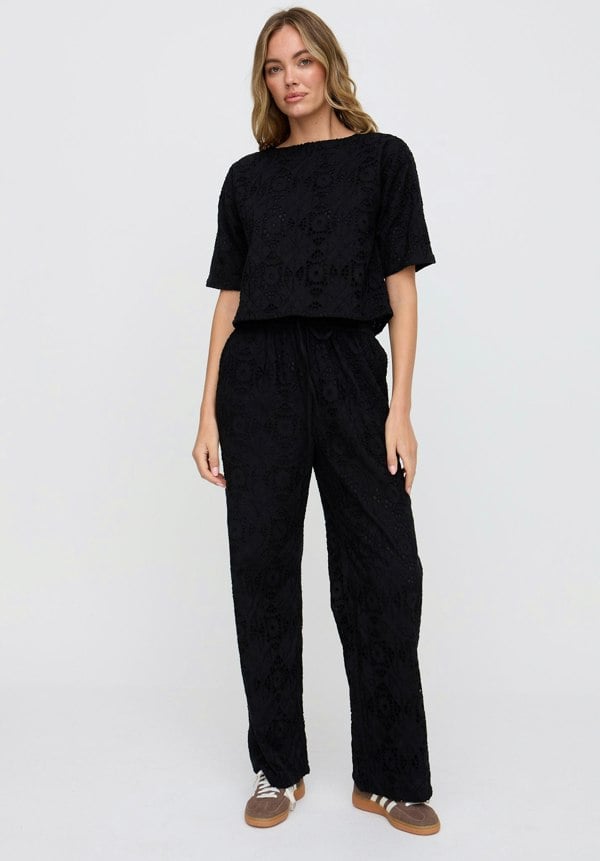 Woman wearing a black outfit on a white background