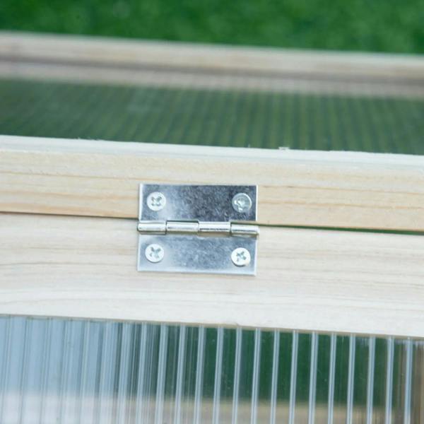 Metal hinge on wooden cold frame greenhouse lid with polycarbonate panel edge