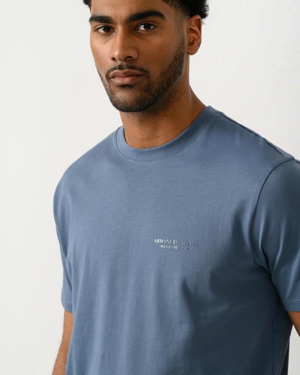 close up shot of a model wearing a Armani Exchange Mens T-Shirt with Small Milano-New York Logo in China Blue