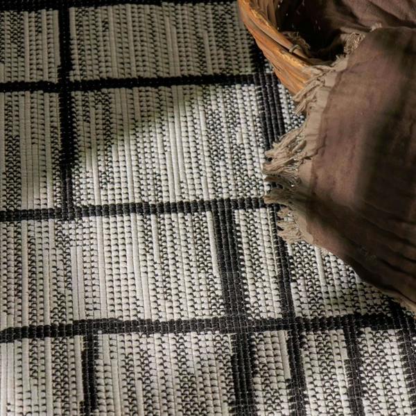 Close-up of a woven rug with a basket on top