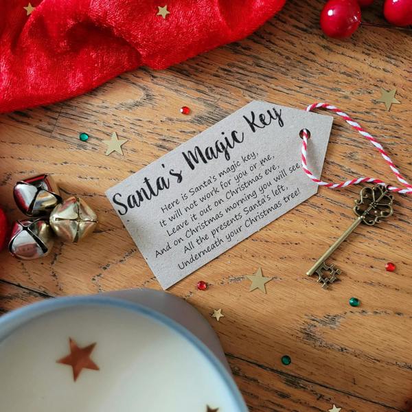 An antique style metal Santa's magic key on red and white string with a printed poem tag on a wooden table.
