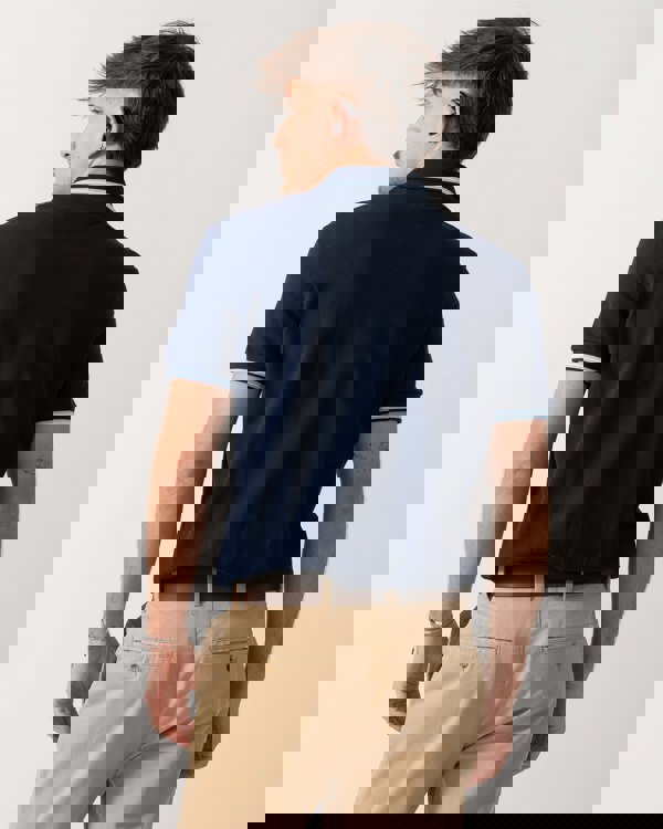 Back shot of a Model wearing a Lacoste Contrast Collar Pique Mens Regular Fit Polo Shirt in Navy Blue