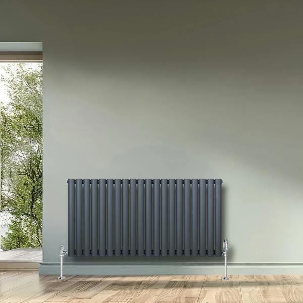 Oval single column radiator in anthracite grey, 600 x 1200mm, featuring sleek vertical lines and a modern design against a neutral wall