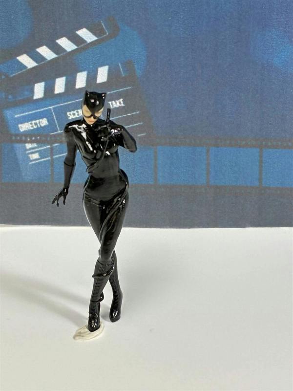 a toy figurine of a woman in a black garment