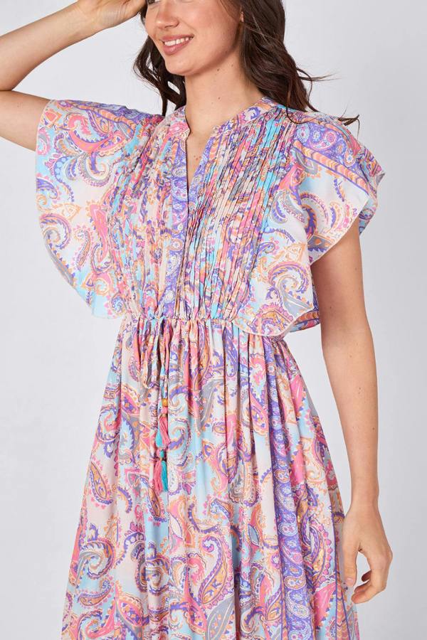 Woman wearing a colorful paisley dress on a white background