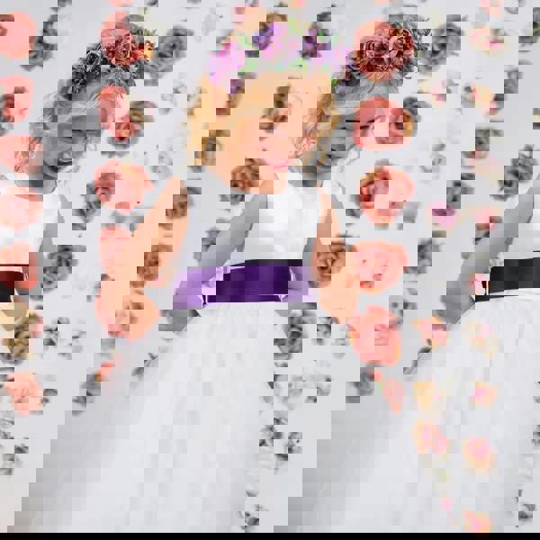 Blonde girl in a white dress with purple sash 