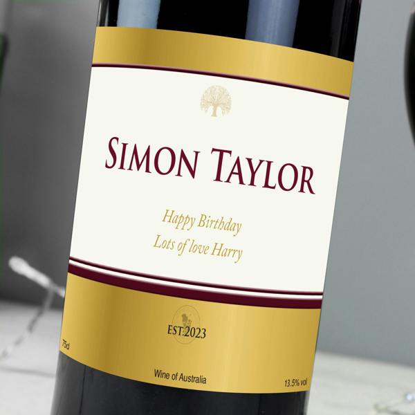 Close-up view of a custom gold label on a bottle of Personalised Red Wine featuring the name SIMON TAYLOR.