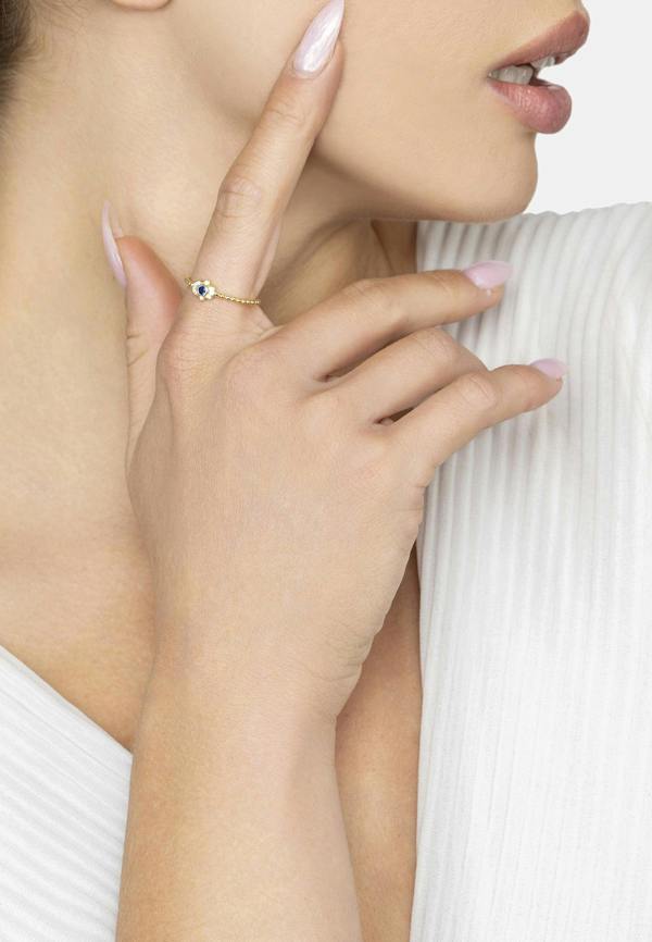 Close-up of a hand wearing a delicate ring with a small gemstone, touching the face.