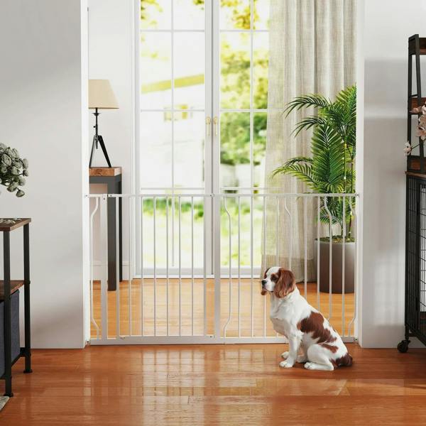 White dog safety gate installed indoors with vertical bars and pet behind it