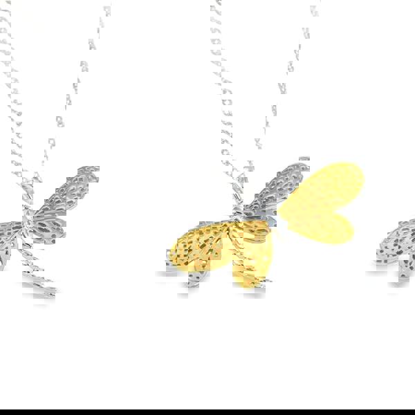 Gold and silver dragonfly pendant with cut outs in its wings, hanging on a silver adjustable chain.