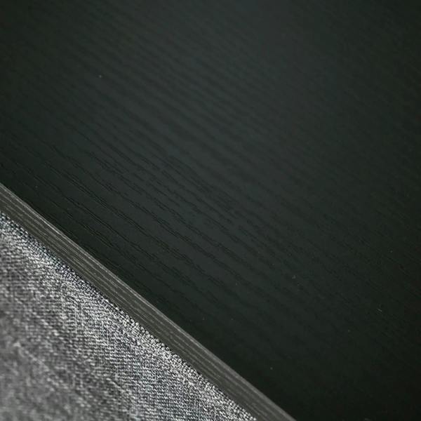 Close-up of grey fabric drawer edge with dark trim along the frame seam
