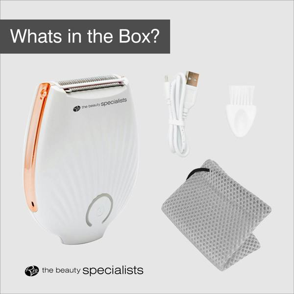 The Rio GO SMOOTH Lady Shaver in white with rose gold accents includes a USB charging cable, cleaning brush, and gray textured pouch. “What’s in the Box?” and “the beauty specialists” logo shown—your go-to for effortless shaving.