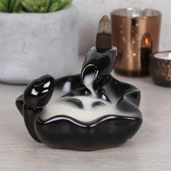 Glossy black hand-shaped incense burner with incense cone and open center bowl for incense
