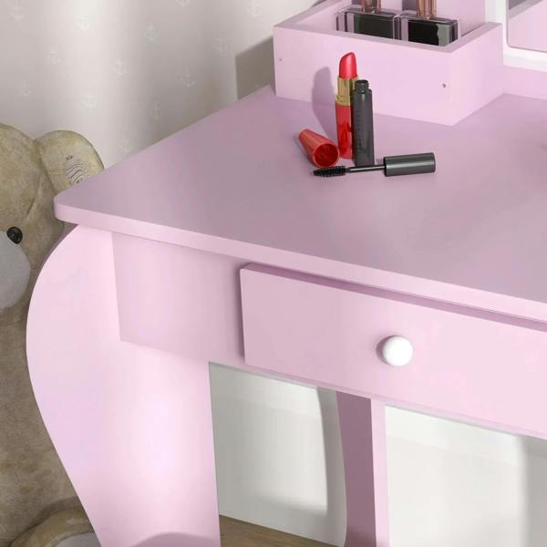 Pink vanity table with drawer and round knob, tabletop with makeup accessories