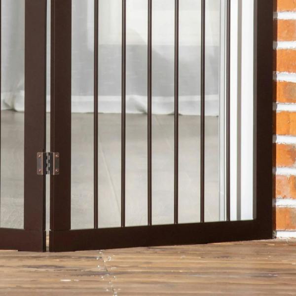 Brown dog safety gate panel close-up with vertical bars and latch hinge