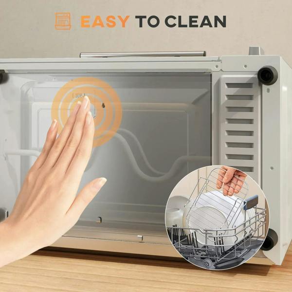 Cream mini oven interior being wiped clean with hand near wire rack and tray