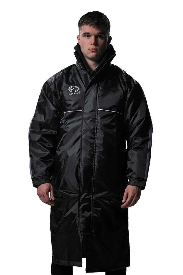 Man wearing long black Optimum sideline sub jacket, front view with white logo, on white - Optimum