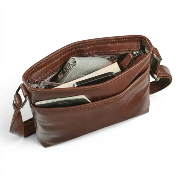 A cognac leather crossbody bag shown open, displaying its interior compartments and pockets filled with items like a wallet and phone. The bag has a matching leather strap and silver-tone hardware, photographed on a clean white background.