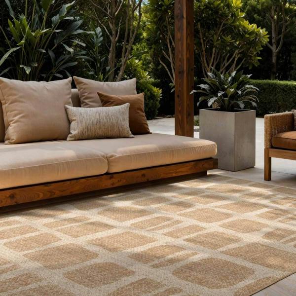 Outdoor patio with beige sofa, patterned rug, and potted plants