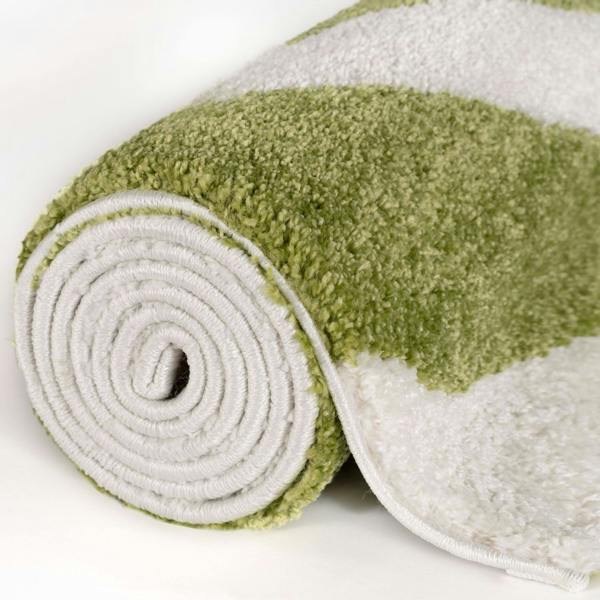 Green and white folded rug on a white background