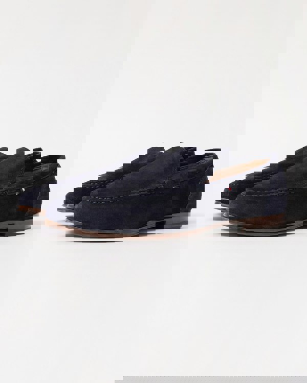 Pair of navy blue suede Tommy Hilfiger loafers on a grey background