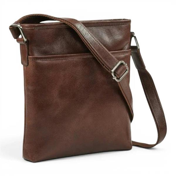 A dark cognac leather crossbody bag with a single adjustable shoulder strap and silver-tone metal hardware, shown on a plain white background.