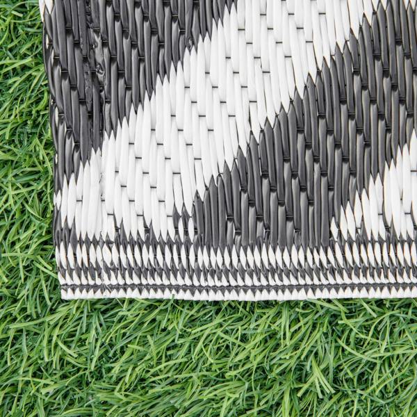 Black and white woven rug edge with fringed border, Greek key pattern.