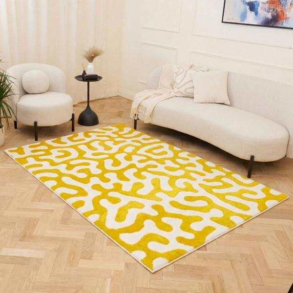 Yellow and white patterned rug on a wooden floor in a living room setting.