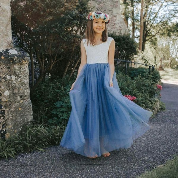 Girl in a garden in a blue and white flower girl dress